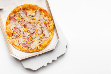 Pizza in delivery box on white table