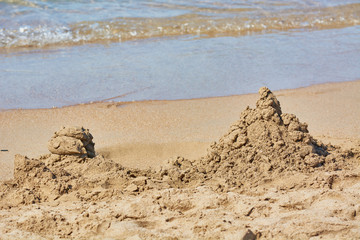 Sandy mountain dug by children on beach seashore.