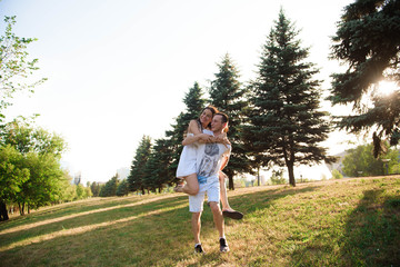 Portrait of the young happy romantic couple who standing in embrace outdoor.