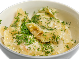Dumplings, filled with cabbage in a plate, isolated on white background. Close up.