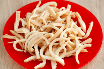 Sliced squid on a bright saucer. Seafood in the form of squid close-up. Cooking dish of squid. Protein in seafood.