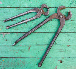 Old nippers on wooden background