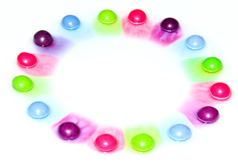 The candies are dissolving in the water and are making a colorful show. 