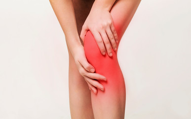 Young woman massaging her painful knee closeup