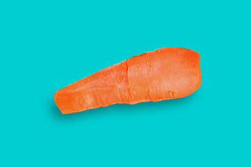 One whole boiled carrot orange color in center of table with blue countertop on kitchen. Top view. Healthy food concept