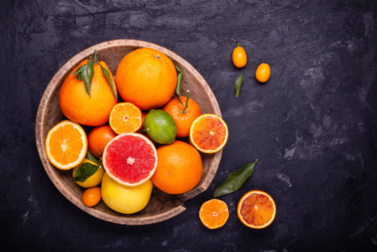 in the old wooden plate, various types of whole citrus fruits and others sliced. © luigi giordano