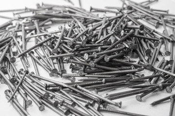 The pile of metal nails lies on the white background.