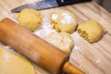 background. a wooden rolling pin with the test lie on a table