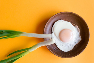 Plate with delicious sunny side up egg on colour background