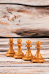 Four chess pawns on wooden background. Row of wooden chess pieces with copy space. Brain benefits...