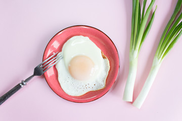 fried eggs and young green onions on the background