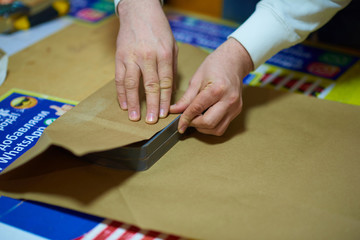 man wraps a gift in paper