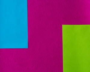 texture of few sheets of coloured paper and fuchsia background
