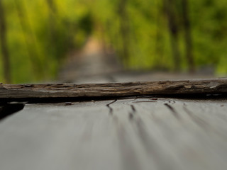 The suspension wooden bridge through the river in the forest. Close up. The long road for courageous and brave through a reservoir at the height of several meters.