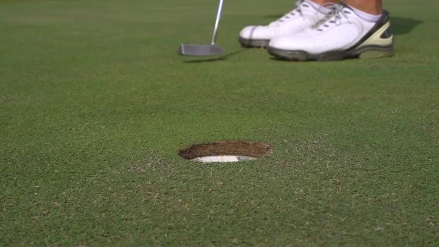 Man golfing and putting in hole. Male player on a golf course - Slider shot