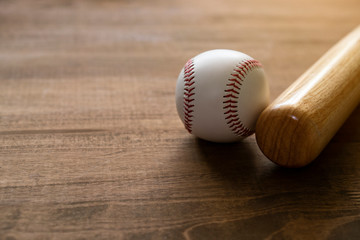 baseball and baseball bat on wooden table background, close up