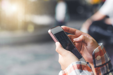 hipster woman using mobile phone touching screen at outdoor with hands typing smart phone texting messaging lifestyle working app device technology internet social data online concept vintage style.