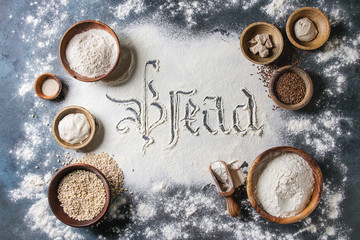 Fototapeta na wymiar Ingredients for baking bread. Variety of wheat and rye flour, grains, yeast, sourdough, gothic calligraphy handwritten lettering bread sifted flour over blue background. Flat lay