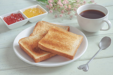 Toast bread on plate with jam and coffee cup
