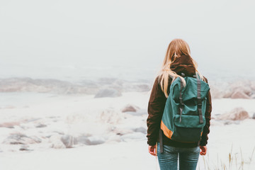 Woman backpacker standing alone outdoor Travel Lifestyle and melancholy emotions concept foggy...