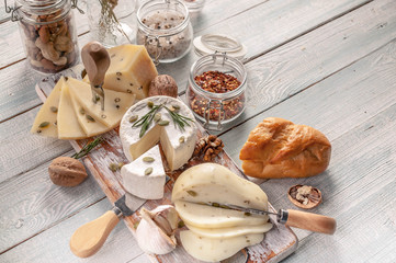 Assorted organic cheese and seasonings on wooden background