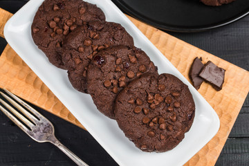 Homemade chocolate cookies on wooden table background. Food baking.
