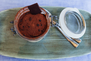 Cream dessert with a biscuit and cocoa in jar. top view