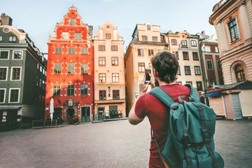 Foto op Canvas Man tourist sightseeing Stockholm city Gamla Stan landmarks traveling lifestyle girl taking photo by smartphone Europe trip summer vacations © EVERST