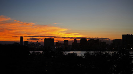 Silhouette of buildings in Asia city with evening sunset and orange sky background.