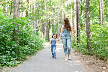 Family and nature concept - Young woman with little girl have fun outdoors