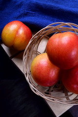 Yellow and red plums in a wicker basket