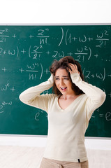 Young female math teacher in front of chalkboard  