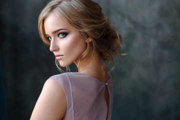 Bride blonde woman in a modern color wedding dress with elegant hair style and make up. Fashion...
