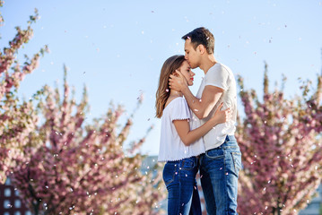 Passion and love concept. Man and woman kissing in blooming garden on spring day. Couple hugs near...