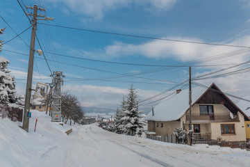 Fototapeta na wymiar Road in Dubovica village in east Slovakia in snow frosty morning