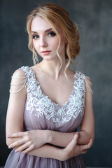 Bride blonde woman in a modern color wedding dress with elegant hair style and make up. Fashion...