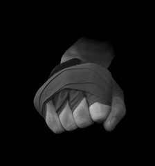 Hand with boxing straps ready to punch in black and white