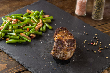 grilled steak from beef sirloin with green beans and bacon