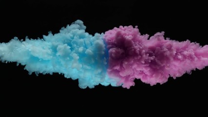 Super slow motion of coloured inks in water. Isolated on black background. Filmed on high speed cinema camera.