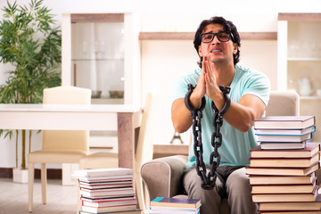 Male student with many books at home 