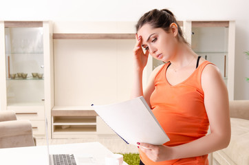 Young pregnant woman working at home 