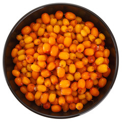 Frozen sea buckthorn berries in a cup. Isolated on white background. View from above.