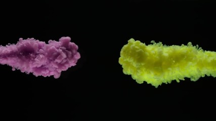 Super slow motion of coloured inks in water. Isolated on black background. Filmed on high speed cinema camera.