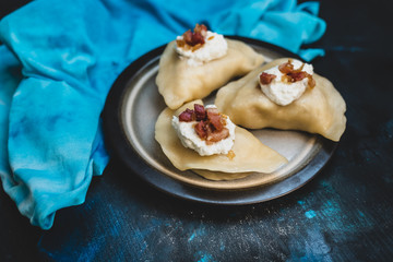 Polish cuisine - delicious dumplings with cheese, potatoes, bacon, onion and sour cream