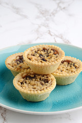 fruit tarts with crumble topping on blue plate
