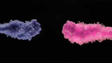 Super slow motion of coloured inks in water. Isolated on black background. Filmed on high speed cinema camera.