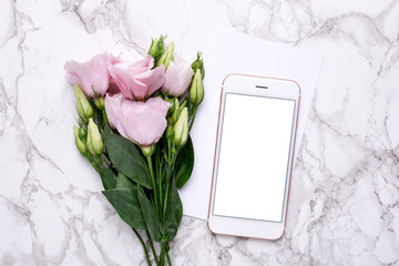 Mobile phone mock up with pink flowers on marble background