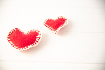 Red knitted soft fabric hearts on white background