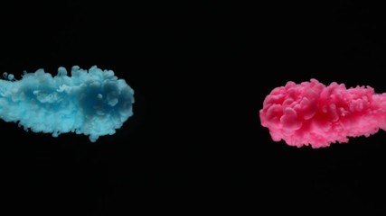 Super slow motion of coloured inks in water. Isolated on black background. Filmed on high speed cinema camera.