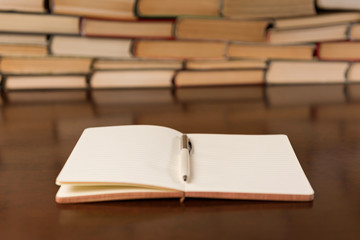 open notebook and books on wooden table